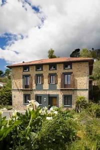 um grande edifício de pedra no meio de um jardim em Casa Rural Enkartada em Sopuerta