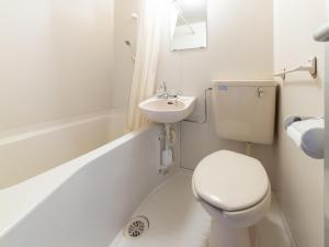 a white bathroom with a toilet and a sink at Tabist Tatsumi Business Hotel Matsusaka in Matsuzaka