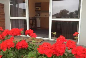 Un mazzo di fiori rossi davanti a una porta di Avon City Motel a Christchurch