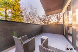 a patio with two chairs and a table and a window at VILLA HAKONE STAGE in Hakone