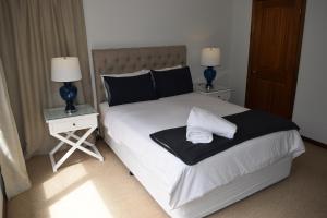 a bedroom with a bed with two night stands and two lamps at Bluebell Cottage in Leura