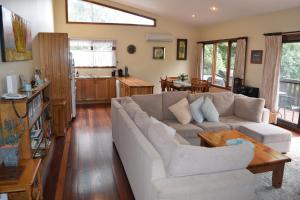 a living room with a couch and a table at Bluebell Cottage in Leura