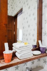 乌鲁瓦图WIRA Homestay & Spa的浴室的台面上堆着毛巾