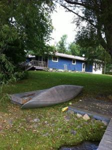 a boat sitting on the grass in front of a house at Seymour Point Cottage in Campbellford