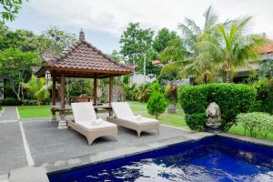 乌鲁瓦图WIRA Homestay & Spa的凉亭和泳池旁的两把椅子