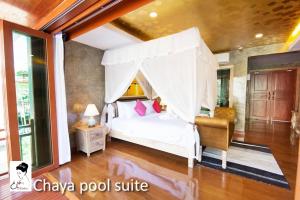 チェンマイにあるザ チャヤ リゾート アンド スパのベッドルーム(天蓋付き白いベッド1台付)