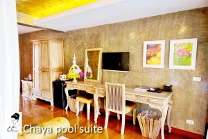 a dining room with a wooden table and chairs at The Chaya Resort and Spa in Chiang Mai