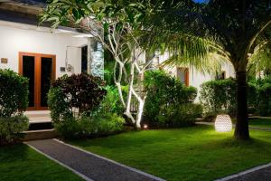 
a house with a tree in front of it at WIRA Homestay & Spa in Uluwatu
