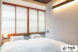 a bedroom with a white bed and a window at Konjaku-So Shinsaibashi Rooftop SPA in Osaka