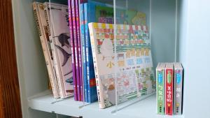 un estante con libros y otros libros para niños en ChaoPingJia Fengge Guesthouse, en Wujie