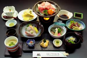 a table topped with bowls of different types of food at Miyajima Seaside Hotel in Miyajima