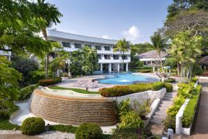 港生Novotel Rayong Rim Pae Resort的一座带游泳池和大楼的度假村