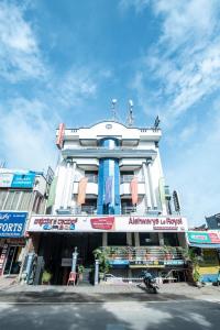 a large white building with an array of signs on it at Aishwarya Le Royal in Mysore
