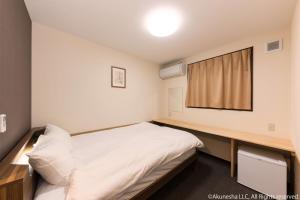 a small room with a bed and a window at Oyado Midokoi in Akune