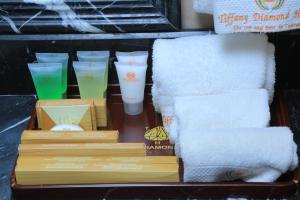 a tray with books and towels and a stack of towels at Tiffany Diamond Hotels Ltd - Indira Gandhi street in Dar es Salaam