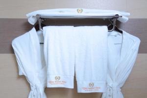 a group of white towels hanging on a towel rack at Tiffany Diamond Hotels Ltd - Indira Gandhi street in Dar es Salaam