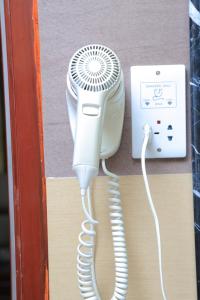 secador de pelo blanco junto a un teléfono blanco en Tiffany Diamond Hotels Ltd - Indira Gandhi street, en Dar es Salaam