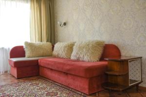 un sofá rojo con almohadas de heno en la sala de estar. en Apartment Horkoho 7A en Shostka