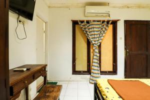 a room with a bed and a window with a curtain at Kos VIP Josh in Yogyakarta +14 photos