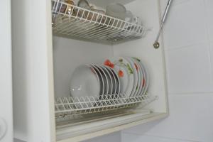a plate rack with plates and dishes in a refrigerator at Apartment Chernovola 7A in Shostka