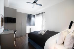 Schlafzimmer mit einem Bett und einem Deckenventilator in der Unterkunft Sleeping Beauty Apartment City Center!! in Thessaloniki