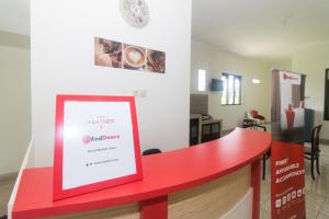 een rode toonbank met een bord in een kamer bij RedDoorz Syariah near Stasiun Madiun in Madiun
