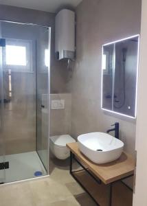 La salle de bains est pourvue d'un lavabo, d'une douche et de toilettes. dans l'établissement Apartments Sunset Zecevo, à Rogoznica