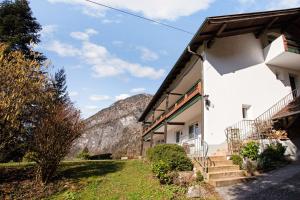 a white building with stairs next to a mountain at Ferienwohnung Haus Reiteralm in Schneizlreuth