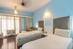 ein Hotelzimmer mit 2 Betten und einem Sofa in der Unterkunft Hotel Jaya International in Hyderabad