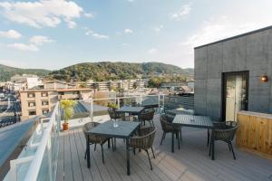 a patio with tables and chairs on a roof at Higashiyama Shikikaboku in Kyoto