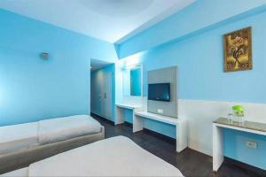 a blue room with a bed and a television at Hotel Jaya International in Hyderabad