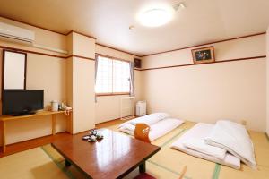 un soggiorno con 2 cuscini e un tavolo di Business Hotel Miharashitei a Kumano