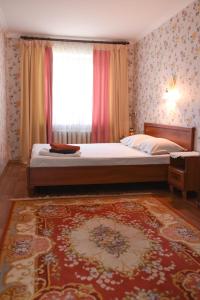 a bedroom with a bed and a window and a rug at Apartment Horkoho 7A in Shostka