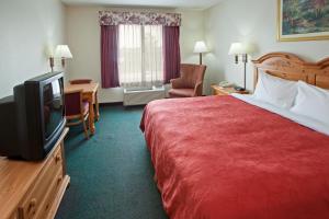 a hotel room with a bed and a flat screen tv at Country Inn & Suites by Radisson, Indianapolis South, IN in Indianapolis