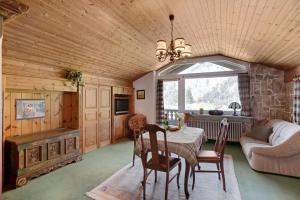 sala de estar con mesa, sillas y sofá en Ferienwohnung Haus Reiteralm, en Schneizlreuth