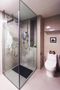 a bathroom with a glass shower with a toilet at Lily and Loft - KL Gateway Bangsar LRT, WIFI, Netflix in Kuala Lumpur