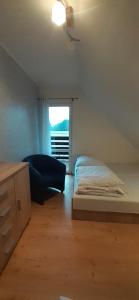 a bedroom with a bed and a window at Domek Rokitki in Rokity