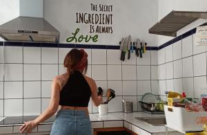 a woman standing in a kitchen preparing food at Casa Calma Yoga Hostel in Agaete