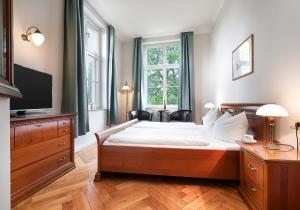 a bedroom with a large bed and a television at Hotel Prinz Heinrich in Werder