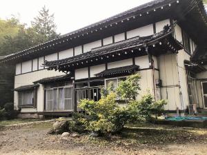 una casa con un árbol delante de ella en Ohanabatake, en Tsuruoka