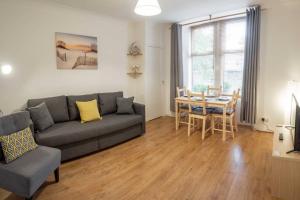 een woonkamer met een bank en een tafel bij ☆ Quiet Ground Floor Apartment Near University ☆ in Dundee