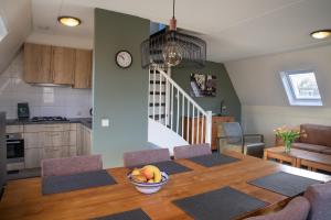 a kitchen and dining room with a table with a bowl of fruit at Vakantie bij Meeussen - Molendal in Plasmolen