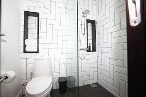 a white bathroom with a toilet and a shower at Blu Monkey Hub and Hotel Phuket Town- Free All Day Coworking space in Phuket Town