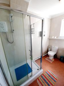 ein Bad mit einer Dusche und einem WC in der Unterkunft Three Bedroom Apartment In Heart Of Rayleigh in Rayleigh