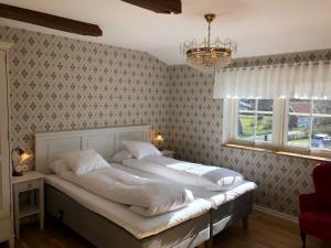 a bedroom with a bed and a window and a chandelier at Kastanjelund in Yngsjö
