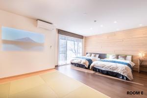 two beds in a room with a large window at VILLA HAKONE STAGE in Hakone