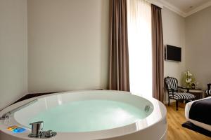 een wit bad in een kamer met een bed bij Ara Suite in Rome