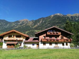 ein großes Haus mit Blumen auf den Balkonen vor Bergen in der Unterkunft Haus Schwaiger in Bad Hofgastein