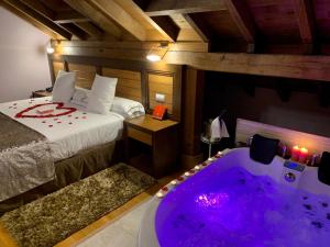 1 dormitorio con cama y bañera en Akla Hotel Suites Valles Pasiegos en Saro