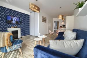 a living room with blue furniture and a fireplace at Mountain Szczyrk ApArt Bratków 10A in Szczyrk